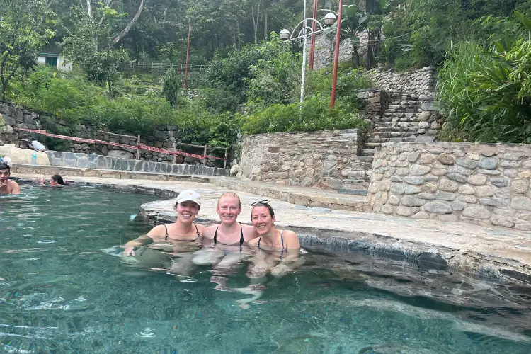 Viajeros relajándose en las aguas termales de colcalmayo durante el Salkantay Trek de 5 días a Machu Picchu